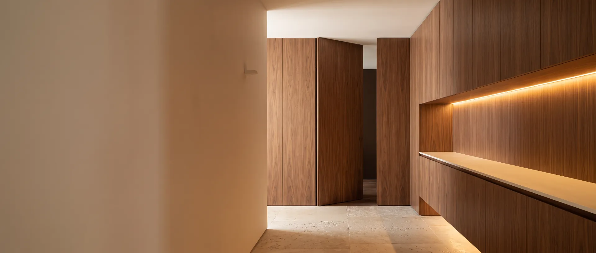 Hallway with walnut wall panels, a concealed flush door and a built-in walnut cabinet